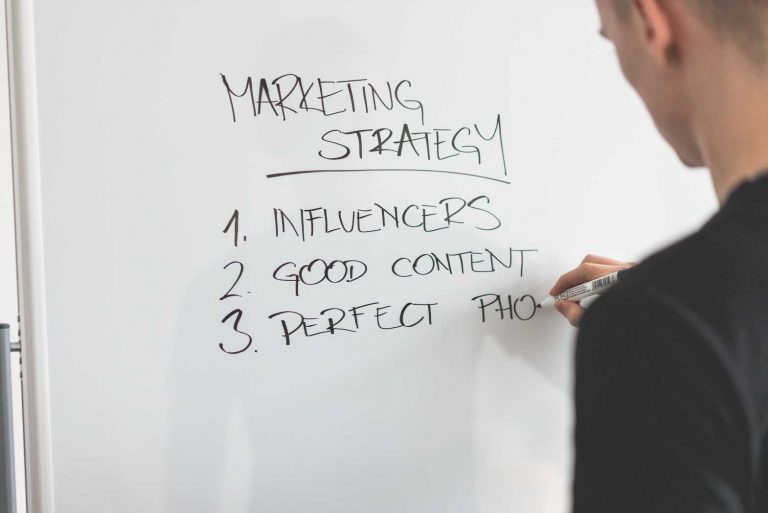 Marketing Expert Writing New Strategy on Whiteboard